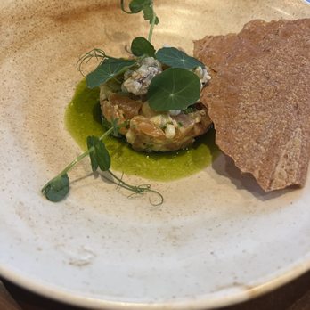 Canoe - Wild game tartar - amazing - A dish with a green sauce, a mixture of ingredients topped with microgreens, and a crispy cracker on a beige plate. - Canadian (New) Near Me - Toronto, Ontario
