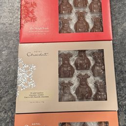 Holiday chocolate - Four boxes of chocolates from Hotel Chocolat, each with different holiday-themed packaging and containing assorted chocolate shapes like bears, trees, and penguins.