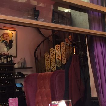 Bistro Saint Dominique - Purple hues of the Bistro as seen through the outdoor seating to the dining room and spiral stairway. - French Near Me - Paris, 75