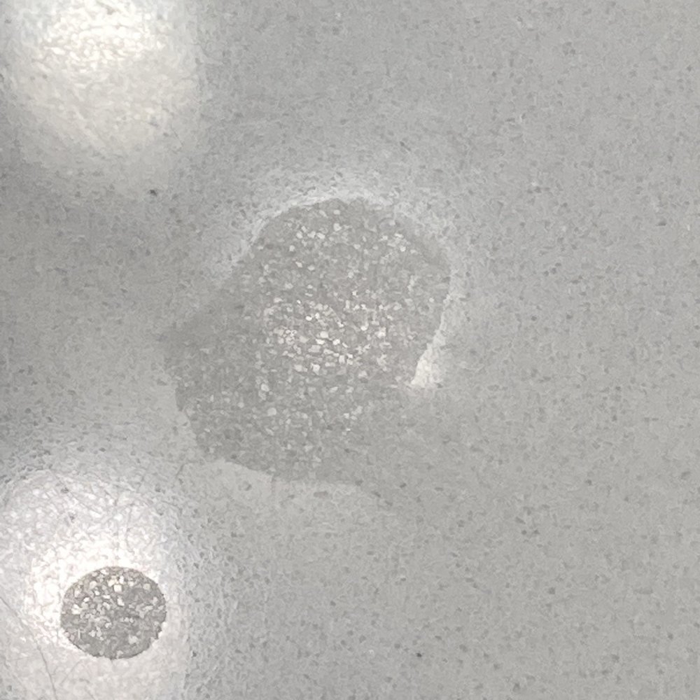 Damaged quartz countertop with chemical etching. Damaged quartz countertop with chemical etching.