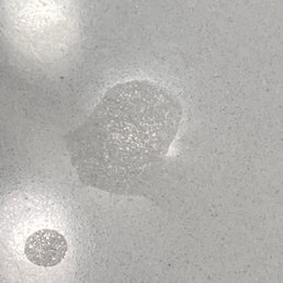 Damaged quartz countertop with chemical etching. Damaged quartz countertop with chemical etching.