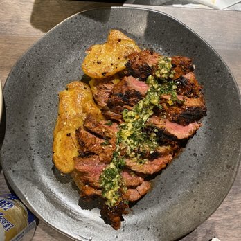 Westward Social - Guajillo Spiced Elk Flank (Sliced, served with chimichurri and smashed fingerling potatoes) - Cocktail Bars Near Me - Big Sky, Montana Westward Social - Guajillo Spiced Elk Flank (Sliced, served with chimichurri and smashed fingerling potatoes) - Cocktail Bars Near Me - Big Sky, Montana