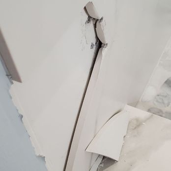 StoneTek Design - Close up of the crack and break. You can see the screw holes for the door and 0....0 mortar behind the tile. - Countertop Installation Near Me - Addison, Illinois