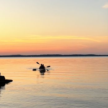 Ahan - two people kayaking in the water at sunset - Laotian Near Me - Madison, Wisconsin