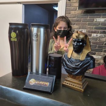 Chambers Escape Games - Our awesome game guide Aniya posing behind mugs for sale ($45) business cards and cool statue - Escape Games Near Me - Honolulu, Hawaii Chambers Escape Games - Our awesome game guide Aniya posing behind mugs for sale ($45) business cards and cool statue - Escape Games Near Me - Honolulu, Hawaii