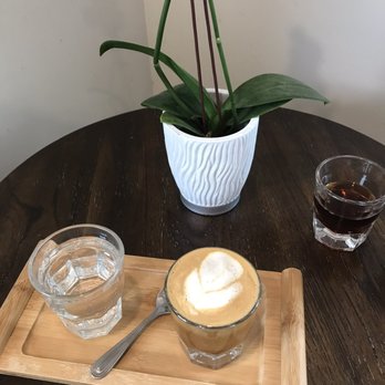 Doppio Coffee - Oat milk cortado (background an orchid and a taster of their coffee today) - Coffee & Tea Near Me - Denver, Colorado Doppio Coffee - Oat milk cortado (background an orchid and a taster of their coffee today) - Coffee & Tea Near Me - Denver, Colorado