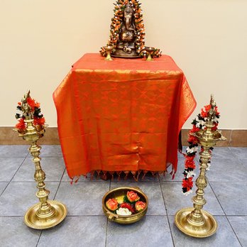 Desi Mane - a table with a red table cloth and gold candles - Indian Near Me - Scarborough, Ontario