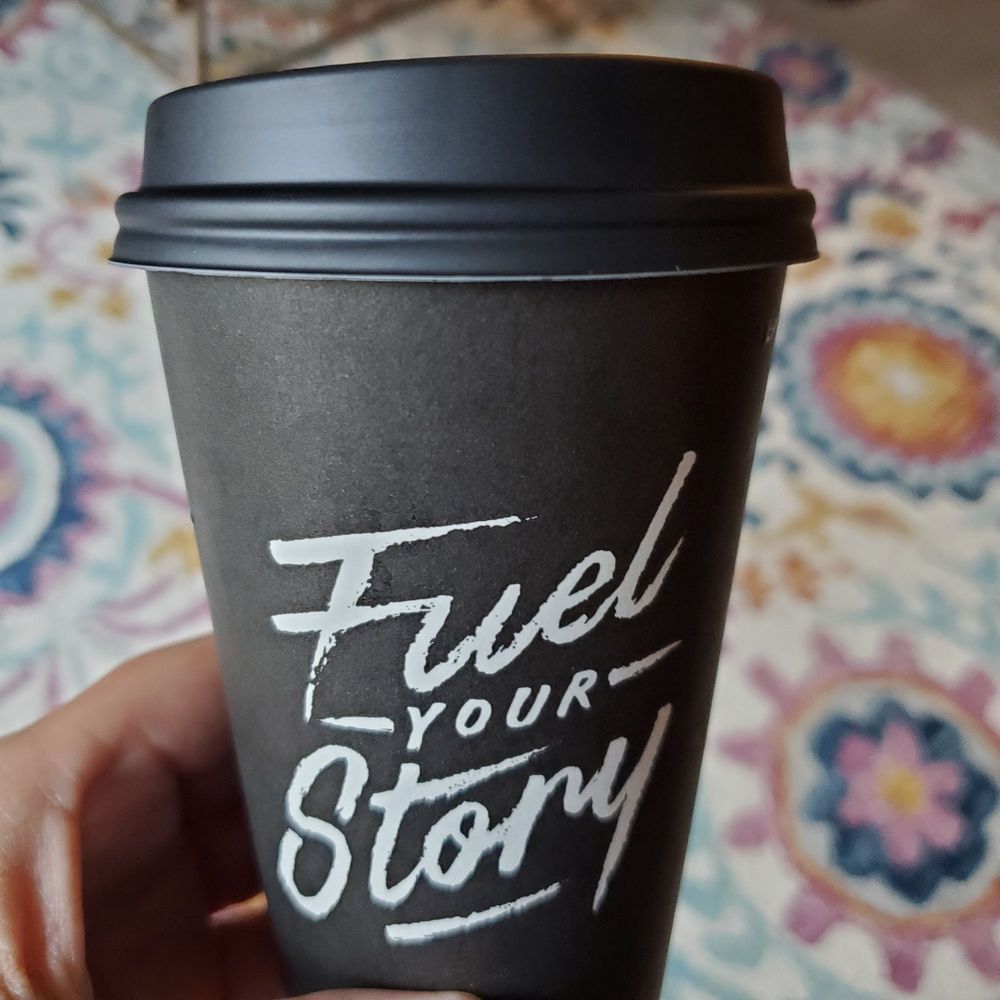 a hand holding a coffee cup