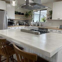 JNM Construction - Kitchen remodel including cabinets, butcher block countertops, range hood installation, concrete island, lighting, paint flooring etc.