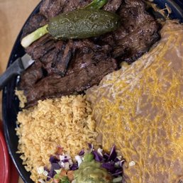 Carne Asada served with refried beans, rice and guacamole.  The fried jalapeño is delicious