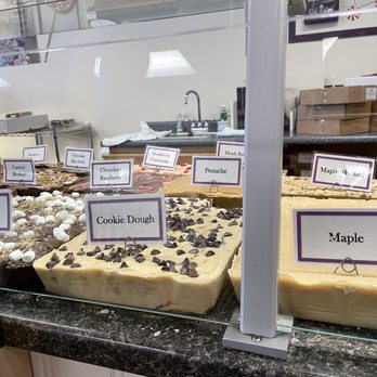 Chutters - a variety of desserts on display - Assorted large fudge blocks with flavor labels like Cookie Dough and Maple are displayed behind a glass case in a candy shop. - Candy Stores Near Me - Lincoln, New Hampshire