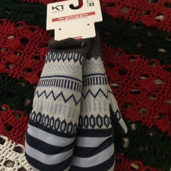 Fleet Feet - Children's mittens with a Nordic pattern in navy, white, and gray are placed on a red, green, and white crocheted tablecloth. - Sports Wear Near Me - Buffalo, New York