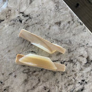 Trussell's Transformations - Two broken pieces of white chocolate are placed on a marble countertop, with a glass container partially visible in the top left corner. - General Contractors Near Me - Albuquerque, New Mexico