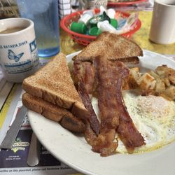 Hot and tasty: 2 eggs over-easy, crispy bacon, fried potatoes and wheat toast.
