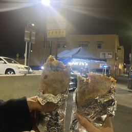 two people holding up tacoss two people holding up tacoss