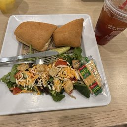 Sweet and smoky chicken sandwich with a side salad. Sweet and smoky chicken sandwich with a side salad.