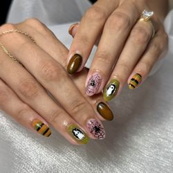 Magic Nails - Custom Halloween nail art with ghosts, spiderwebs, and colorful striped designs at Magic Nails in Buena Park, CA.