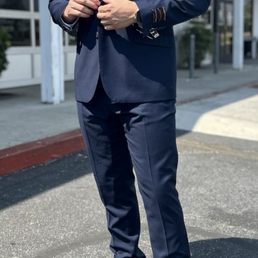 Male model outside in a dark blue suit with a bow tie and white buttoned up dress shirt. Male model outside in a dark blue suit with a bow tie and white buttoned up dress shirt.