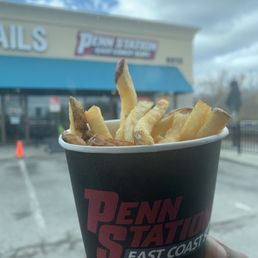 a hand holding a cup of fries