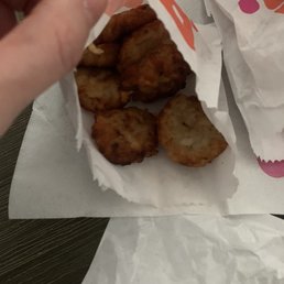 a hand holding a piece of fried food a hand holding a piece of fried food