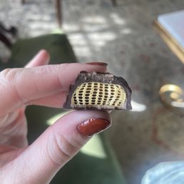 a hand holding a piece of chocolate