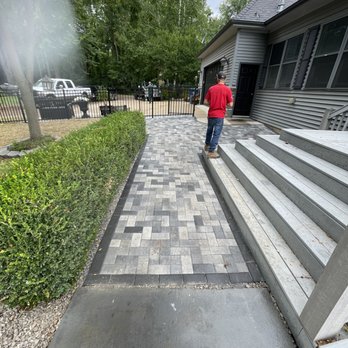 Peterson’s Landscape Construction - a man walking up the steps of a house - Landscaping Near Me