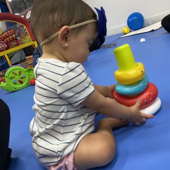Playland - a toddler playing with a stacking toy - Fast Food Near Me - Doral, Florida