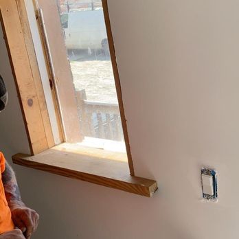 Tiger Home Building - a man in an orange vest working on a window - General Contractors Near Me Tiger Home Building - a man in an orange vest working on a window - General Contractors Near Me