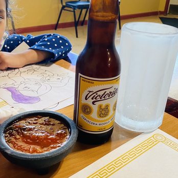 Los Hermanos Mexican Restaurant - a little girl sitting at a table with a bowl of chili and a bottle of beer - Mexican Near Me - Sutter Creek, California Los Hermanos Mexican Restaurant - a little girl sitting at a table with a bowl of chili and a bottle of beer - Mexican Near Me - Sutter Creek, California