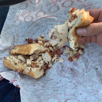 Quiznos - a hand holding a half eaten sandwich - Sandwiches Near Me - Edwardsville, Illinois