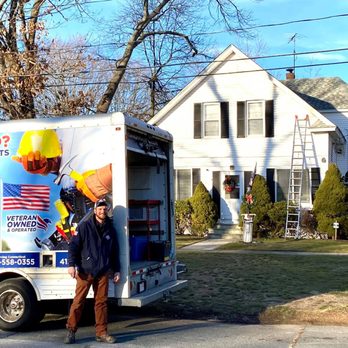 Handyman First Class - a man standing in front of a moving truck - Handyman Near Me Handyman First Class - a man standing in front of a moving truck - Handyman Near Me