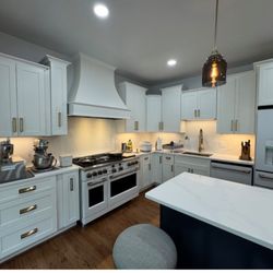 Kitchen remodel with a multilevel cabinet design, hardwood flooring and quartz countertops and backsplash