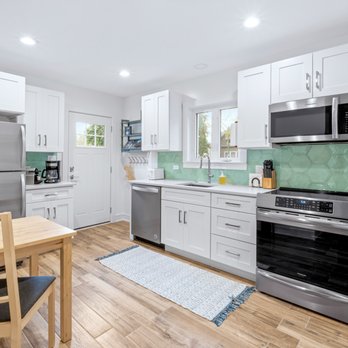 ALS Remodeling - a kitchen with white cabinets and stainless steel appliances - General Contractors Near Me - Chicago, Illinois
