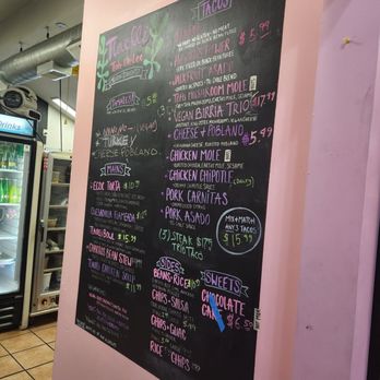 Tlaolli - A chalkboard menu at Tlaolli restaurant displays Mexican cuisine options, including tacos, mains, sides, and desserts, with prices and descriptions. - Mexican Near Me - Indianapolis, Indiana