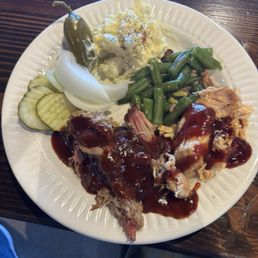 Plate from the buffet. Pork, chicken, green beans, potato salad and garnish.
