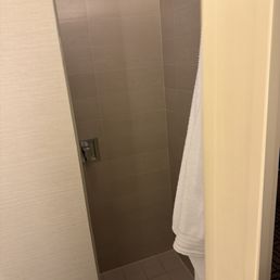 Entrance to the tiny shower hidden behind the bathroom door.