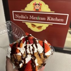 Nydias Mexican Kitchen - Buñuelos topped with whipped cream, strawberries, and chocolate drizzle