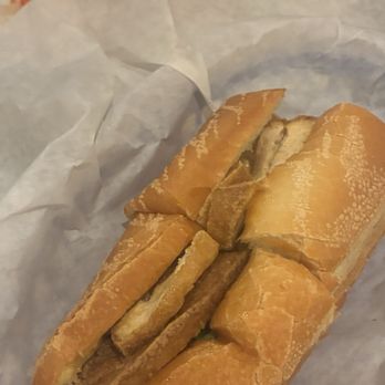 Pho Minh - A fried chicken sandwich with breaded chicken pieces in a hoagie bun, placed on crumpled white paper, likely from a casual dining setting. - Soup Near Me - Temecula, California