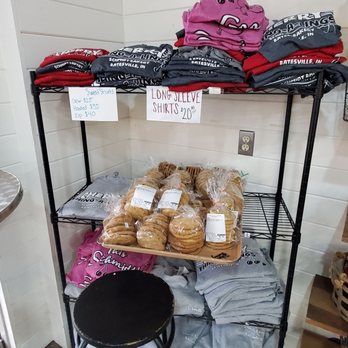 Schmidt Bakery - T-shirts and sweatshirts - Black metal shelves hold T-shirts and sweatshirts with Batesville, IN branding on the top, and baked cookies and pastries on the middle shelf at Schmidt Bakery. - Donuts Near Me - Batesville, Indiana