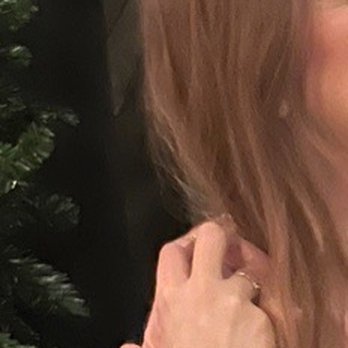 Drybar - River North - What I got nothing as Cosmo style :( - A woman with long, wavy hair is captured in a close-up, partial profile, with her hand near her face, in an indoor setting. - Blow Dry/Out Services Near Me - Chicago, Illinois