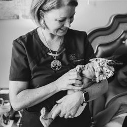 Frisco Birth Center - Margie (midwife) holding a little girl after birth