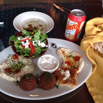 Dallah Mediterranean Cuisine - Clockwise from the top: Greek salad, hummus, spanakopita, falafel, baba ghanouj, with salad dressing in center of plate. Blackcurrant soda. - Mediterranean Near Me - San Antonio, Texas Dallah Mediterranean Cuisine - Clockwise from the top: Greek salad, hummus, spanakopita, falafel, baba ghanouj, with salad dressing in center of plate. Blackcurrant soda. - Mediterranean Near Me - San Antonio, Texas