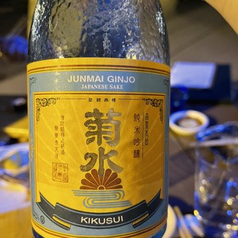 Kuni's - a person holding a bottle of sake - Sushi Bars Near Me - Buffalo, New York