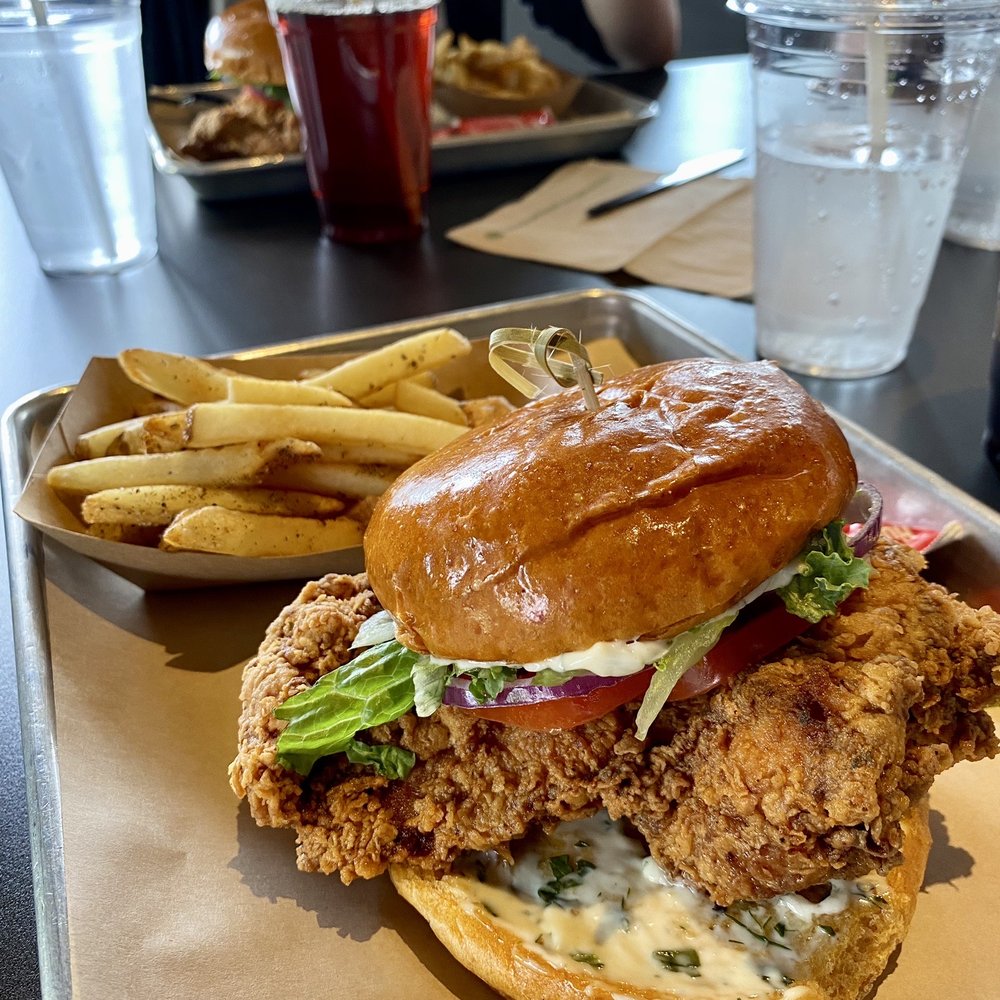 Roots Chicken Shak - The Big Bird Chicken Sandwich (Sweet potato bun, seasonal kale salad, pickles & tomatoes, red onion, herb mayo), $7.95 and Duck Fat Fries $3 - Chicken Wings Near Me - Austin, Texas