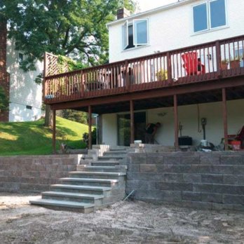 One Service - a view of a back yard with steps leading up to a deck - Landscaping Near Me - Fairport, New York One Service - a view of a back yard with steps leading up to a deck - Landscaping Near Me - Fairport, New York