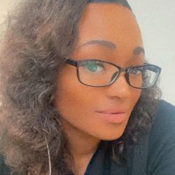 Tia Watkins Chair - Headshot of a woman with black glasses, light skinned tone and wavy light brown hair.