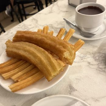 Chocolatería San Ginés - Golden, crispy churros paired with rich, velvety dark hot chocolate at Chocolatería San Ginés. The perfect Madrid treat, any time of day. - Chocolatiers & Shops Near Me - Madrid, M