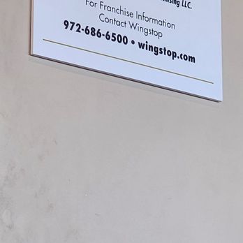 Wingstop - a sign on the wall of a restaurant - Chicken Wings Near Me - Cathedral City, California