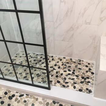 Interior Redesign - a walk - in shower with black and white pebbles - General Contractors Near Me - North Olmsted, Ohio