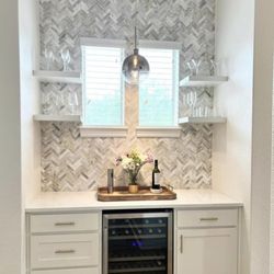 JDL Home Design - Wine bar with custom soft close cabinets with herringbone pattern backsplash, granite countertops and floating shelves.